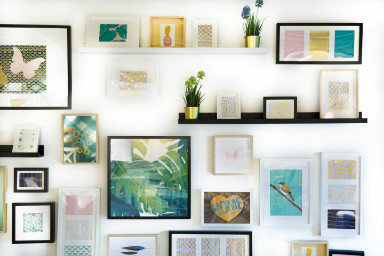 A wall covered in decor, such as shelves, plants, mirrors, and pictures.