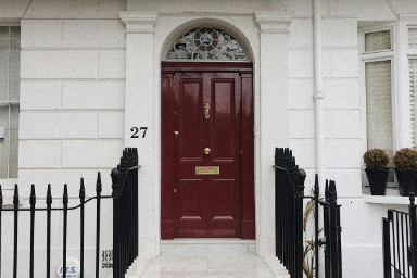 Red door with a half moon window above it.